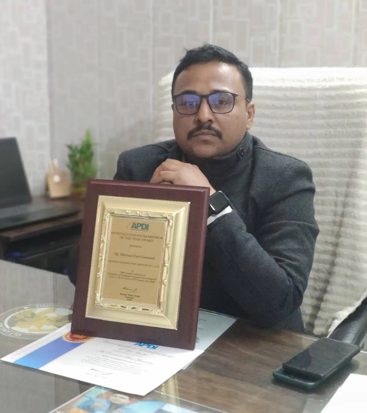 Chandigarh Private Detective agency owner with award at office.
